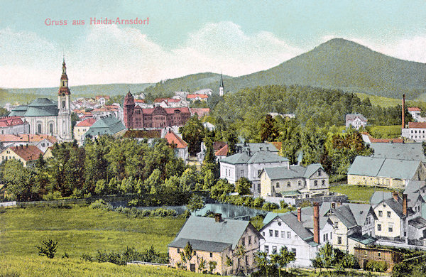 This picture postcard from the beginning of the 20th century shows in the foreground the houses of the Ulice Svatopluka Čecha street below the Borský vrch-hill. In the background on the left side there ist the town of Nový Bor with the church Assumption of the Virgin Mary and the prominent red building of the savings bank, on the horizont there is the Chotovický vrch hill.
