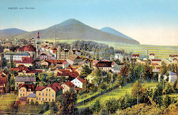 Diese Ansichtskarte aus der Zeit vor dem 1. Weltkrieg zeigt den Blick auf das Stadtzentrum vom Borský vrch. Im Vordergrund stehen die Häuser an der Strasse nach Svor (Röhrsdorf), inmitten der Bebauung sieht man den Stadtplatz mit der Kirche Mariä Himmelfahrt und dem Gebäude der Sparkasse, zwischen denen die damalige Poststrasse (heute T. G. Masaryk-Gasse) nach hinten hinausläuft. Am Horizont ist der Chotovický vrch (Kottowitzerberg), rechts hinter ihm der weiter entfernte Skalický vrch (Langenauer Berg) und links der niedrigere Lipový vrch (Limberg).