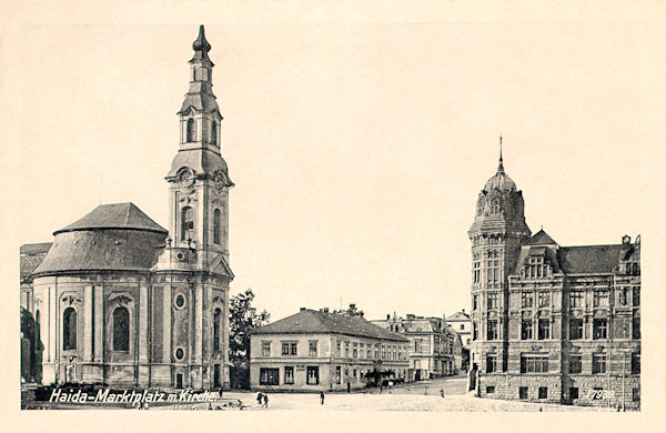 Auf dieser Ansichtskarte aus den 30er Jahren des 20. Jahrhunderts sieht man die Südseite des Stadtplatzes mit der Kirche Mariä Himmelfahrt und dem monumentalen Gebäude der Sparkasse. Zwischen ihnen ist die damalige Poststrasse mit dem Gasthaus „Zur Post“ im Vordergrund.