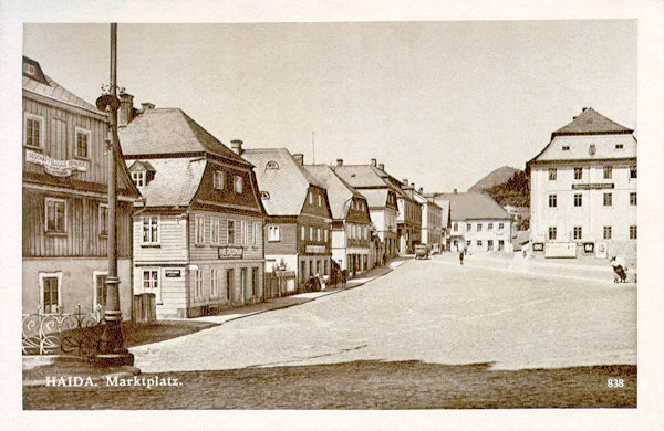 Tato pohlednice zachycuje domy na západní straně náměstí. Vpravo je bývalá panská sýpka, která byla v roce 1821 upravena pro potřeby městského úřadu, jemuž slouží i dnes.