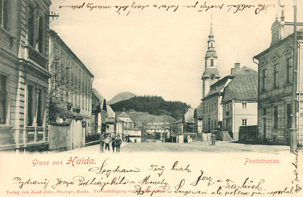 Diese Ansichtskarte vom Jahr 1901 zeigt den Anfang der damaligen Poststrasse (heute T. G. Masaryk-Strasse) kurz vor dem Bau des neuen Sparkassagebäudes. Rechts ragt der Turm der Mariä Himmelfahrt-Kirche über die Häuser herauf.