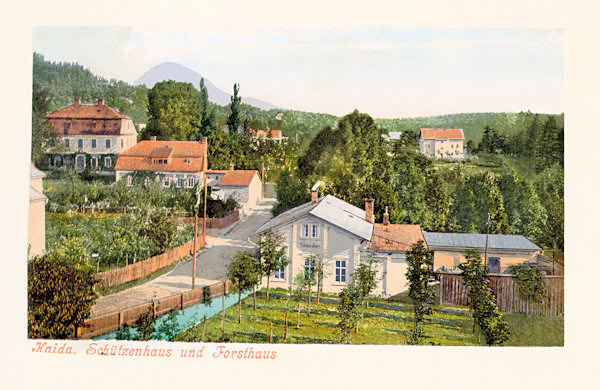 Auf dieser Ansichtskarte sieht man das ursprüngliche Haus der Schiessstätte in der Schützengasse (heute Křižík-Gasse). Im Hintergrund sieht man das ehemalige Forsthaus, am Horizont ragt der Klíč (Kleis) empor.