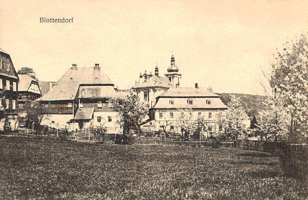 Auf dieser Ansichtskarte sieht man die Kirche der Heiligen Dreifaltigkeit, die zum Teil von einem Hause, das heute nicht mehr existiert, verdeckt wird. Links steht die frühere Pfarre.