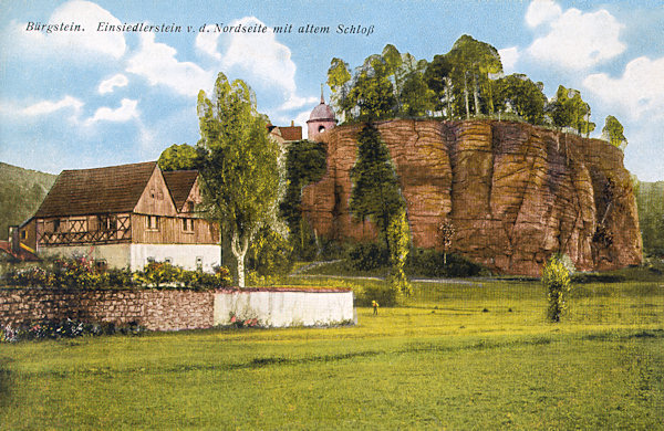 On this picture postcard from the twenties of the 20th century you see the rock tower of the Poustevnický kámen (Hermite-rock) and in the foreground the building of the former castle called Berkovský zámek.