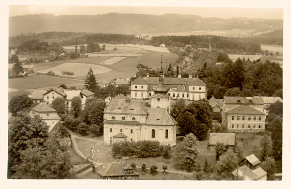 This picture postcard shows the elevated place in the centre of the village with the church of St. Catherine and the castle of the family of count Kinsky. To the right of the church there is the school, to the left behind the trees the presbytery and behind of it the former seignorial hotel.