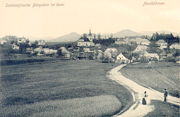 This picture postcard shows the central part of Sloup village as seen from a hilll on the path to the chapel Záhořínská kaple.