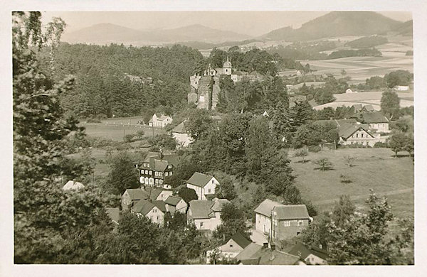 Diese Ansichtskarte zeigt das Südende von Sloup mit dem Felsenklotz des Poustevnický kámen (Einsiedlerstein).