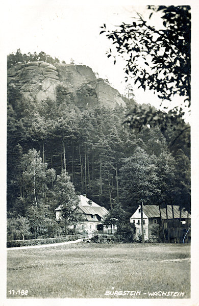 This picture postcard shows the small houses standing on the foot of the rock cliff Na Stráži along of the path leading to the open-air theatre, the former main road of the village.