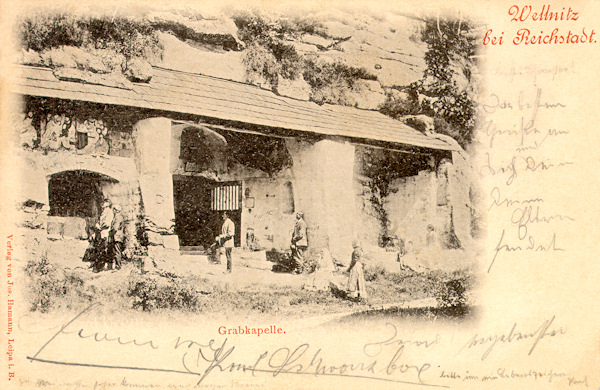 This postcard from 1898 shows the Holy Sepulchre chapel carved 1711 into a rock at the road from Velenice to Brniště. On the wall of the chapel there are still the stone reliefs with the secrets of the Rosary which later were removed. The entrance steps of the chapel were buried during the construction of the road.