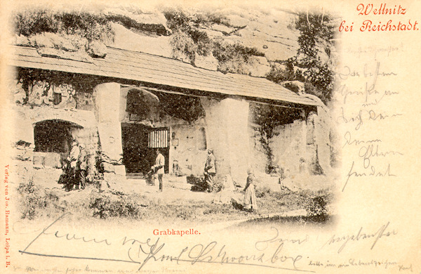 Diese Ansichtskarte aus dem Jahre 1898 zeigt die Heilige-Grab-Kapelle, die 1711 in einen Felsen an der Strasse von Velenice (Wellnitz) nach Brniště (Brins) ausgehauen worden ist. An der Kapellenwand stehen noch die steinernen Reliefe mit den Geheimnissen des Rosenkranzes. Die Stufen zum Eingange der Kapelle wurden beim Strassenbau verschüttet.