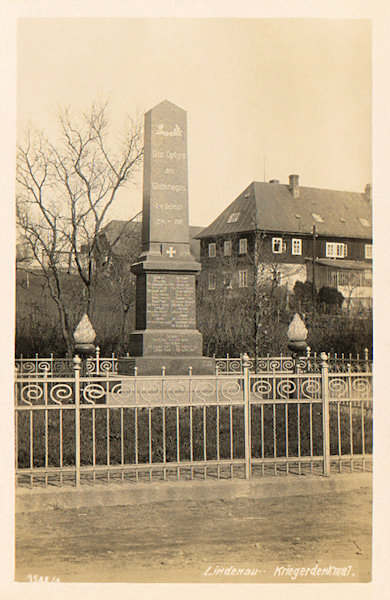 Auf dieser Ansichtskarte sieht man das am 24. Juli 1924 enthüllte und im Jahre 1945 zerstörte Denkmal der Gefallenen des 1. Weltkrieges. Im Hintergrunde stehen die Gebäude des Pfarrhofes.