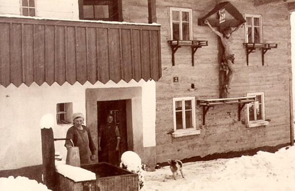Auf dieser winterlichen Fotografie aus der ersten Hälfte des 20. Jahrhunderts sieht man das frühere Haus No. 2 mit dem grossen Holzkreuz an der Wand.