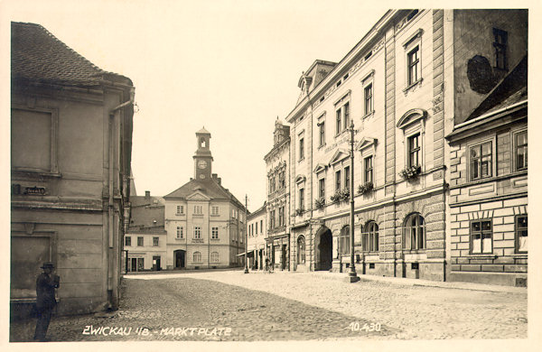 Na meziválečné pohlednici vidíme horní část náměstí mezi Panským domem a hotelem „U Zlatého lva“. Věžička radnice má od roku 1919 sníženou stříšku.