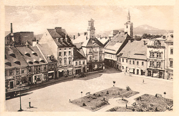 Tato pohlednice zachycuje jihozápadní část náměstí s radnicí kolem roku 1947. Na místě zbořeného Panského domu byl tehdy již upravený parčík.