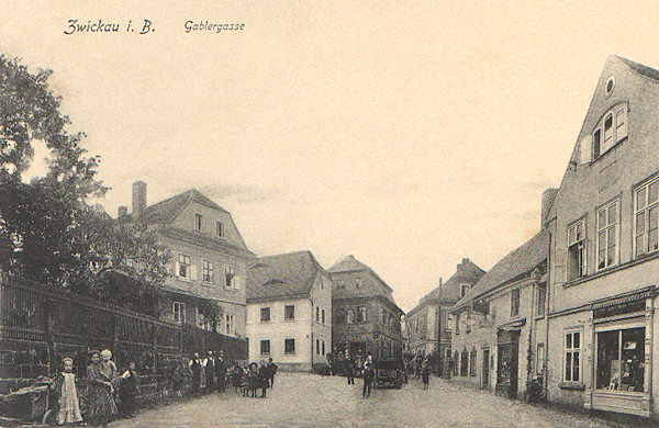 Tato pohlednice zachycuje domy v Mlýnské ulici pod náměstím. Většina z nich zde stojí dodnes, jen druhý dům vpravo byl ve 2. polovině 20. století zbořen.