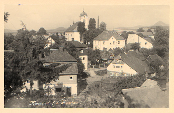 This picture postcard shows the church of Elevation of the Holy Cross from 1833 the tower of which with its height of 32,5 m has a peculiar uninterchangeable shape. The picture was made from the Zámecký vrch where in former times stood a small castle.