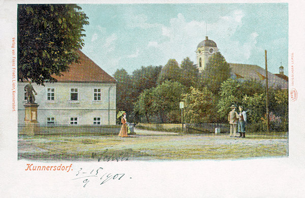 Auf dieser Ansichtskarte aus der Wende des 19. und 20. Jahrhunderts sieht man das Haus der Volksschule mit dem Denkmal Kaiser Josefs II. und der Kreuzeserhöhungs-Kirche im Hintergrund.