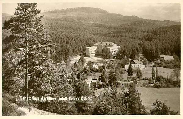 This picture postcard shows the outlook from the Bartelberg over the surroundings of the pulmonary sanatorium at Martinovo Údolí. To the right in front of he new sanatory building from 1932 there is the building of the original steam bath.
