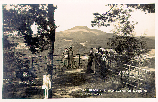 Diese Ansichtskarte zeigt die Schillerwarte am Nordhang des Zelený vrch (Grünberg), ein beliebtes Ausflugsziel der Einwohner Zwickaus. Die Aussicht in das Land wird abgeschlossen von zweigipfeligen Hvozd (Hochwald).