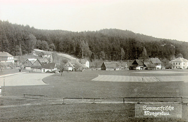 Die Ansichtskarte aus den 20er Jahren des 20. Jahrhunderts zeigt den mittleren Teil von Rousínov von Norden. Ganz links sieht man einen Teil der ehemaligen Schneider-Mühle, aus der Häusergruppe vor ihr ragt das Türmchen der St. Valentin-Kapelle, die nach dem 2. Weltkrieg abgerissenen wurde, heraus, am rechten Rande des Bildes sieht man die 1898 erbaute ehemalige Volksschule.