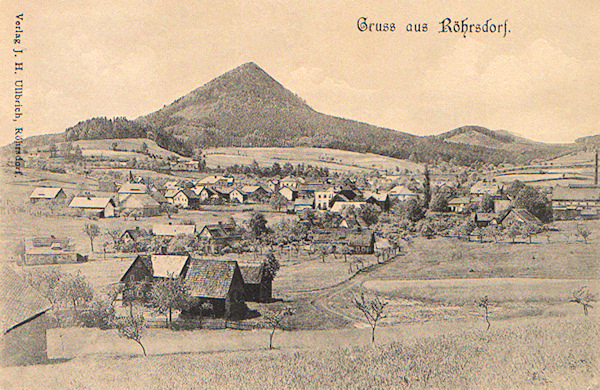 On this picture postcard you see the whole village picturesqely spread under the prominent cone-shaped peak of the Klíč hill.