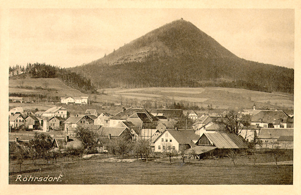 Diese Ansichtskarte von 1915 zeigt das Niederdorf von Svor (Röhrsdorf) ungefähr aus östlicher Richtung. Oberhalb des Dorfes links sieht man das Bahnhofsgebäude, über ihm die Kuppe des Sokolík (Falkenberg) und darüber den massiven Kegel des Klíč (Kleis), auf dessen Gipfel deutlich die Schutzhütte zu sehen ist.