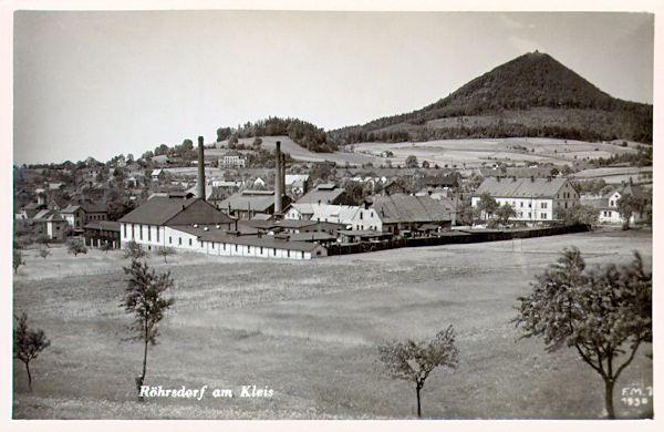 Auf dieser Ansichtskarte von 1930 sieht man im Vordergrund die 1873 gegründete Glashütte „Theresiental“. Am Horizont ragt der Klíč-Berg empor.