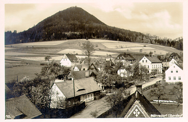 This picture postcard shows the houses in the upper part of the village as seen from the railway bridge. In the background there is the Klíč-hill.