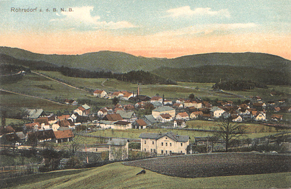 Diese Ansichtskarte zeigt Svor (Röhrsdorf) vom Gipfel des Sokolík (Falkenberges). Im Vordergrund liegt man den Bahnhof in seiner ursprünglichen Form, in der Ortsmitte ist deutlich das heute als Gemeindeamt dienende Haus und rechts von ihm die beiden grösseren Gaststätten. Die Fläche zwischen der Gemeinde und dem Bahnhof war damals noch nicht bebaut.