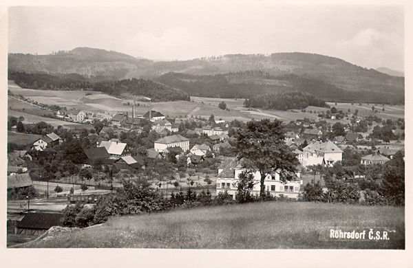 This picture postcard from the 30s of the 20th century shows the village of Svor as seen from the slope of the Sokolík-hill. Behind the tree in the foreground the new railway station building is already standing and to the right behind of it there is the new building of the Czech school.