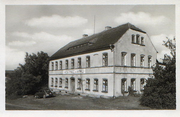 Diese Ansichtskarte von 1953 zeigt das an der alten Strasse nach Nový Bor (Haida) an der Abzweigung zum Bahnhof stehende frühere Gasthaus „U Hyků“. Das Haus steht auch heute, aber sein Aussehen wurde durch einen späteren Umbau vollständig verändert.