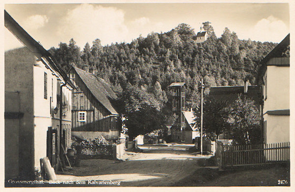 This picture postcard from the 30s of the 20th century shows the chapel on the Calvary-hill as seen from the main road near the branch road to Heřmanice. In front of Richter's inn then stood the fire-brigade's tower produced by the iron foundry Neuwinger in Mařenice, in the foreground to the left there is Anton Engel's grocery in the house No. 161.