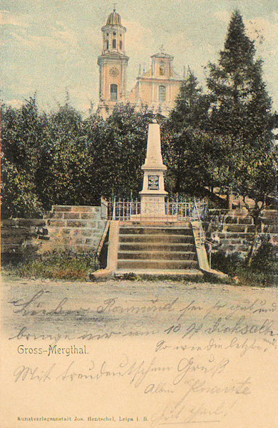 Auf dieser Ansichtskarte sieht man das früher vor den Kirche St. Maria Magdalena stehende Denkmal der Opfer des preussisch-österreichischen Krieges 1866. Es wurde 1933 als Denkmal der Gefallenen des 1. Weltkrieges renoviert, nach dem 2. Weltkrieg wurde es entfernt.