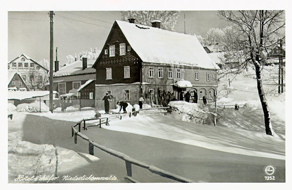 Auf dieser historischen Winteransichtskarte von 1947 ist das an der Abzweigung der Strasse nach Horní Světlá (Oberlichtenwalde) stehende ehemalige Hotel Schäfer. Im Hintergrund links ragt der Giebel des früheren Hotels Adler hervor.