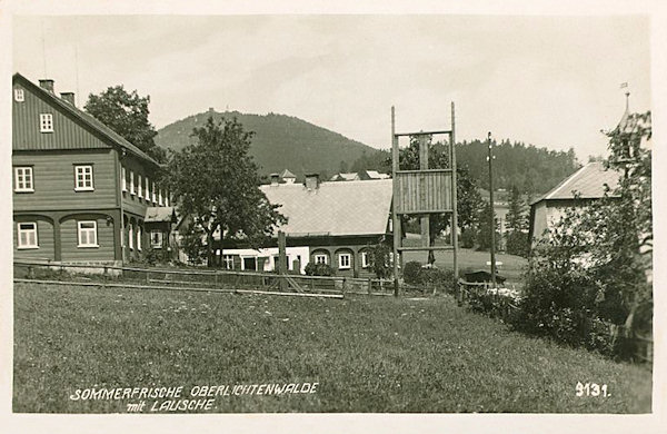 Na této pohlednici vidíme dva domy uprostřed osady. Vpravo za stromy vyčnívá bývalá kaplička.