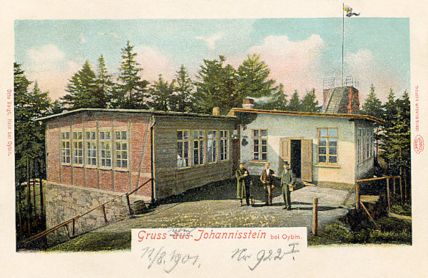Auf dieser Ansichtskarte aus der Wende des 19. und 20. Jahrhunderts sieht man das ursprüngliche Gasthaus auf den Johannissteinen (Janské kameny). Im Hintergrund ragt die auf dem Basaltfelsen erbaute Aussichtsplattform hervor.