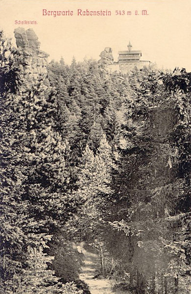 Auf dieser Ansichtkarte aus dem Jahr 1921 sieht man das ehemalige Gasthaus auf den Krkavčí kameny (Rabensteinen) im Blick von der deutschen Seite der Grenze. Im Vordergrund links ragt der Felsturm des Schalksteins empor.