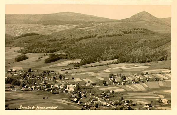 This picture postcard shows Krompach as seen from the southern peak of the Hvozd (Hochwald) hill. In the background there is the acute cone of the Luž hill and on its left side the prolongated crest of the Pěnkavčí vrch hill.