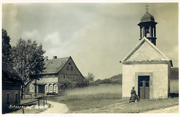 Diese Ansichtskarte zeigt die Kapelle Mariä Heimsuchung, die am nordöstlichen Ende des Dorfes stand und nach 1945 abgerissen worde. Auch die beiden Nachbarhäuser, die zur Zeit der Entstehung dieses Fotos dem Familien Kindermann und Stengel gehörten, gibt es nicht mehr.