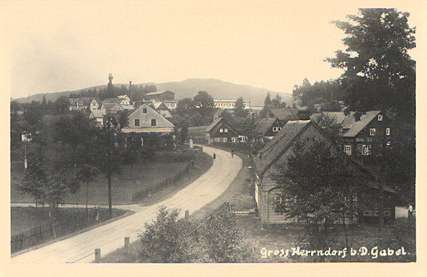 Diese Ansichtskarte zeigt den unteren Teil von Kněžice (Gross-Herrndorf, Gross-Hirndorf) an der Strasse nach Lvová (Lämberg). Das Bild der Gemeinde wird beherrscht von den Gebäuden der Giesserei und Wirtschaftsmaschinen-Fabrik, die 1887 von dem aus dem sächsischen Lückendorf stammenden Anton Schicht gegründet worden ist.