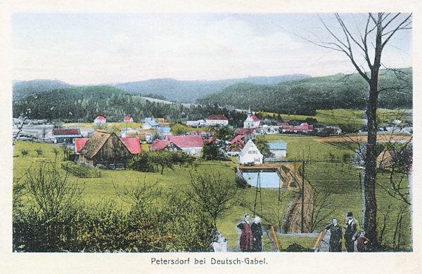 Diese Ansichtskarte aus der Zeit vor 1930 zeigt Petrovice mit der Dreifaltigkeitskirche im Blick vom Westen vom Fusse des Sokol (Falkenberg).