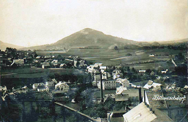 This picture postcard shows the southern part of Jablonné and Česká Ves, taken from the former brewery. In the centre of the picture we see a factory building standing near of the bridge over the Panenský potok-brook and behind of it the peak of the evangelical church. In the background there is the Tlustec-hill.