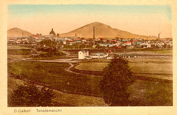 This picture postcard shows the town with the cathedral of St. Laurentius and St. Zdislava as seen from the north. In the foreground there is the prison and detention camp which from 1914 to 1921 was situated in the fields near the present-day swimming-pool. Behind the town there is the Tlustec-hill and in the left background the Ralsko-hill.