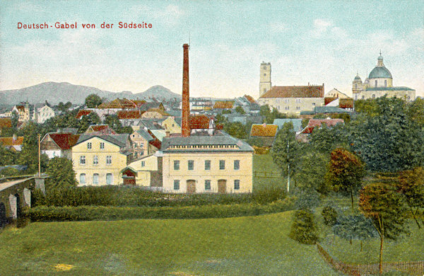 On this picture postcard from 1919 we see the southern part of the town as seen from Česká ves. On the left there is the bridge over the Panenský-brook and besides it the building of a factory which in its only marginally changed outlook is standing here to the present days. In the background rise over the houses of the town the former church of the Birth of Virgin Mary and the basilica of the Saint Laurentius and Saint Zdislava protrude over the roofs of the houses of the town.