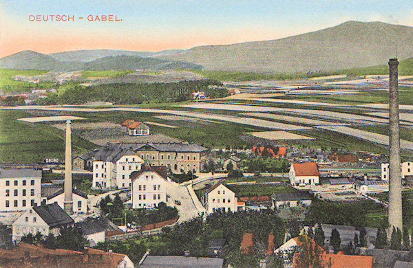 This picture postcard from the years before World war I shows the building of the railway station of Jablonné with the workshops of the present company Preciosa standing in front of it. Interesting is the view of the characteristic patch-work of small fields the longer sides of which are directed to the village Lada. In the horizon to the right there is the Hvozd-hill.