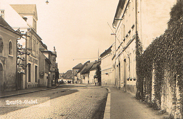 This picture postcard shows the former road to Zittau and Liberec as seen from the cemetery. In the foreground on the left a part of the St.-Wolfgangs chapel is seen, on the right side of the street up to now only both the two nearest houses in the foreground remained.