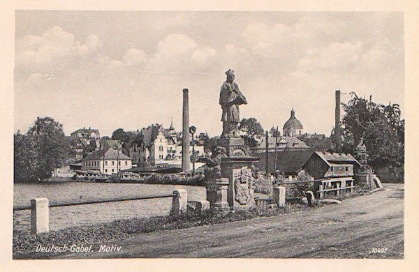 On this picture postcard we see the beautiful baroque sculpture of the St. John of Nepomuk standing together with the neighbouring sculpture of St. Zdislava on the bridge in the dam of the Mlýnský rybník (Mill pond). Both these sculptures had later been transfered to the Dome of St. Lawrence and St. Zdislava.