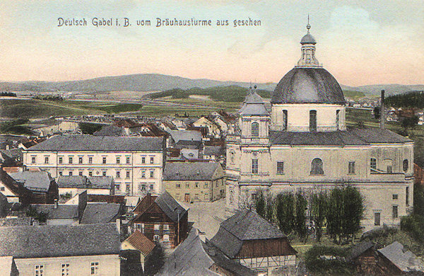 Diese Ansichtskarte, aufgenommen vom Turme des früheren bürgerlichen Bräuhauses, zeigt den barocken Dom des hl. Laurentius und der hl. Zdislava, die Dominante der ganzen Stadt. Links davon steht das monumentale Gebäude der städtischen Ämter aus dem Jahre 1890.