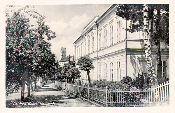 Auf dieser Ansichtskarte aus der Zeit um 1940 sieht man das damalige Krankenhaus in der Tyrš-Gasse. Im Hintergrund steht die ehemalige Bierbrauerei, die durch Umbau der ausgebrannten Maria Geburt-Kirche entstanden ist.