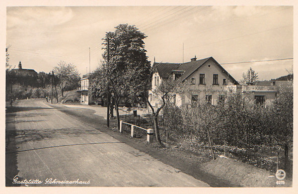 This picture postcard shows the central part of the village with the wayside inn „Schweizerhaus“ in the foreground. In the background the castle Lemberk is seen.